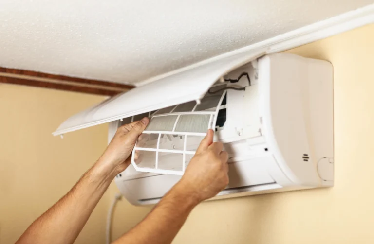 Technician removing and cleaning the filter on a ductless mini split indoor unit for a Midland TX home