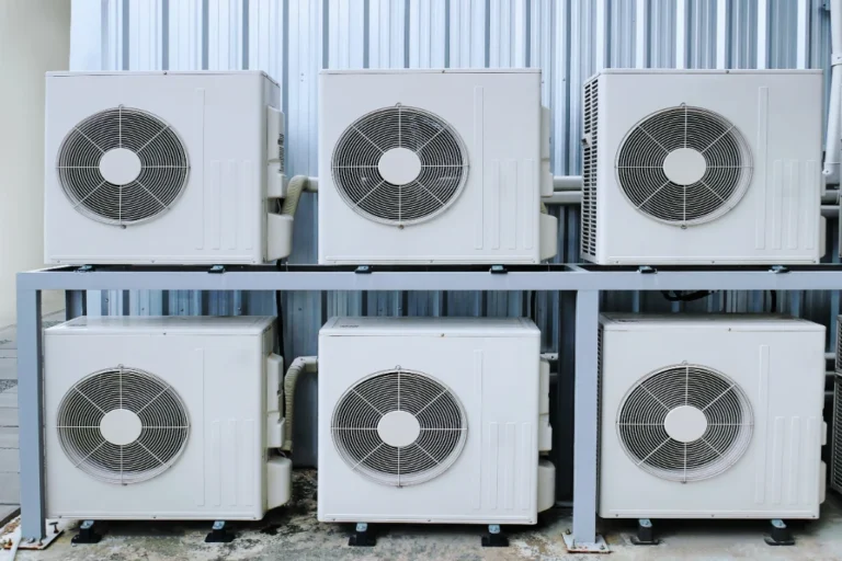 Multiple outdoor AC condenser units mounted on a rack, illustrating HVAC system lifespan in Texas.