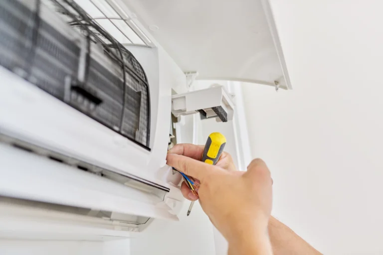 GENMECH HVAC technician wiring a ductless mini-split air conditioner indoor unit at an apartment.