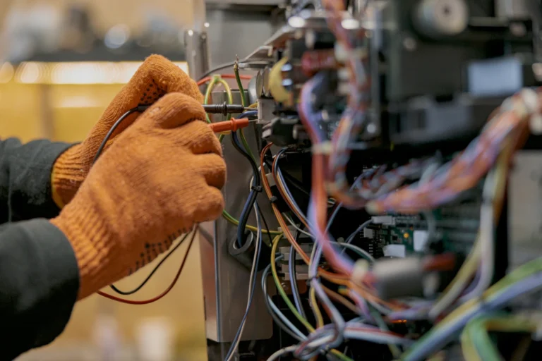 An appliance repair technician in Midland, TX, testing appliance control board wiring with multimeter probes